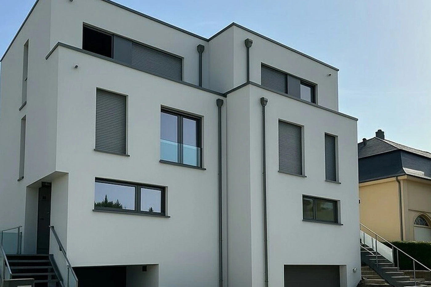 Façades avant de maisons modernes avec garages et escaliers extérieurs