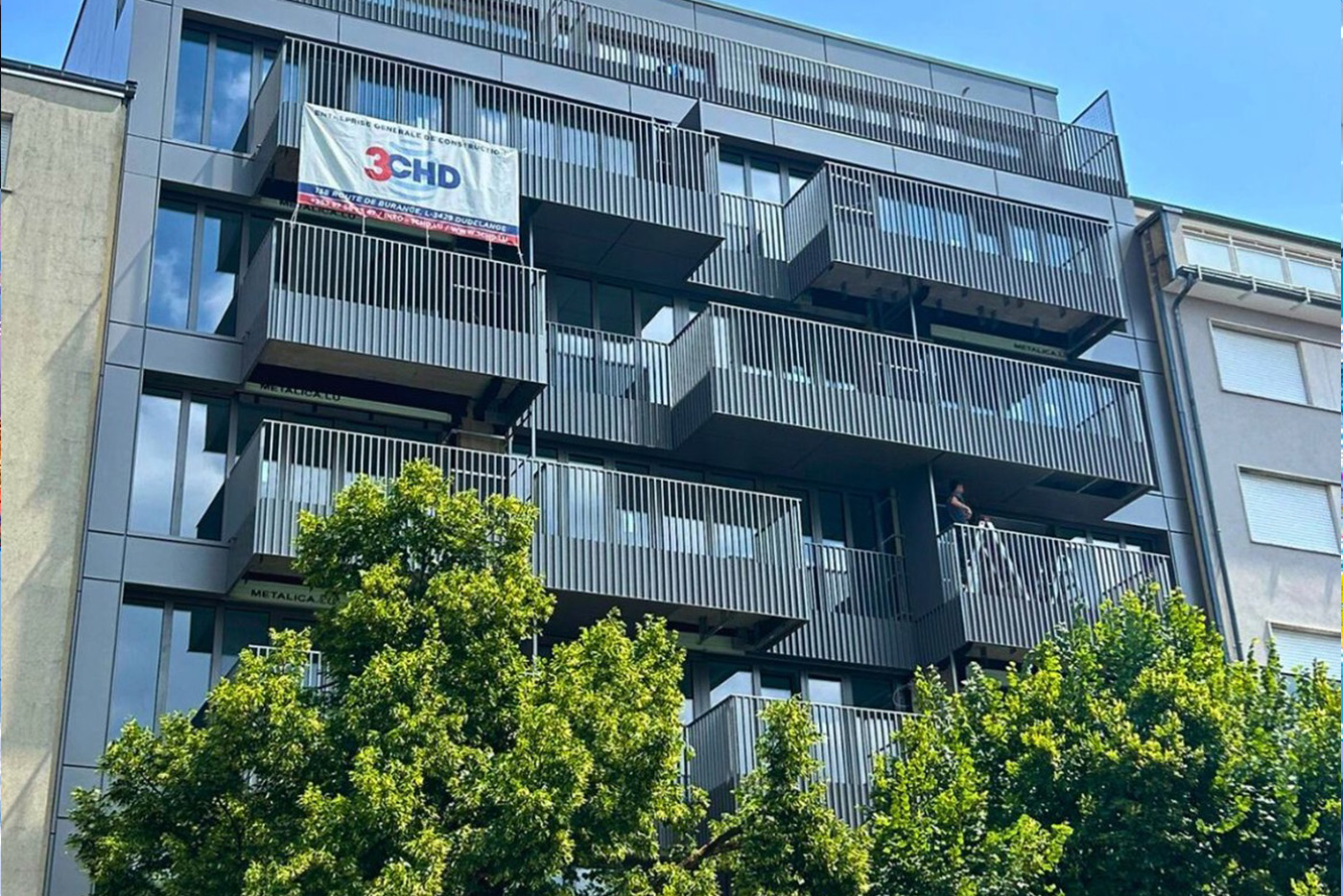 Façade moderne avec terrasses en saillie et brise-soleil métalliques de la résidence