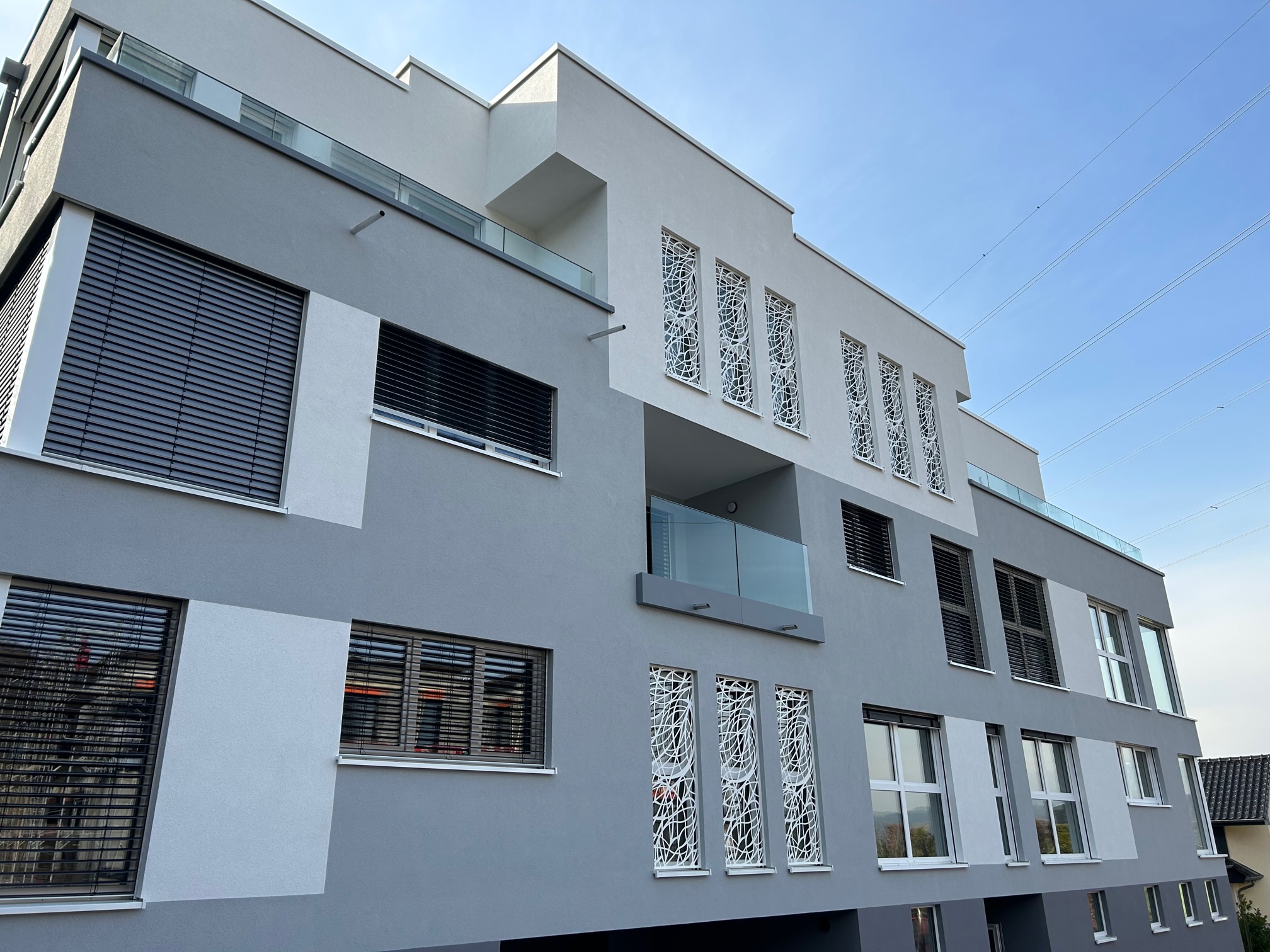 Façade avant d’un immeuble résidentiel moderne avec balcons en verre à Heisdorf